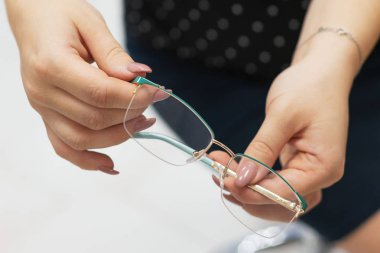 Güzel, modern bir kadın optik mağazasından yeni okuma gözlüğü seçiyor. Vizyon düzeltmesi. Oftalmoloji. Kapatmak için