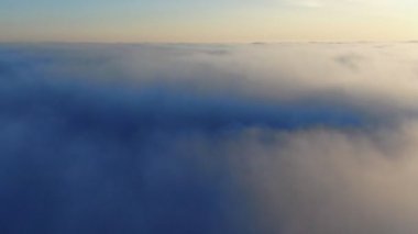 Turuncu sabahta ya da akşam güneşinde güzel bulutların üstündeki destansı hava manzarası. Gün doğumunda ya da günbatımında gökyüzünde kabarık bulutlar arasında uçan drone..