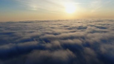 Turuncu sabahta ya da akşam güneşinde güzel bulutların üstündeki destansı hava manzarası. Gün doğumunda ya da günbatımında gökyüzünde kabarık bulutlar arasında uçan drone..