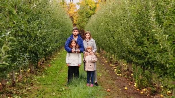 Вид на повітря молода сім'я з чотирьох перебування в яблуневому саду — стокове відео