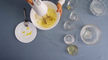 Manzarada para kazanan bir kız var. Mangırı elektrikli mikserle karıştırıyorum. Evde yemek pişirmek..