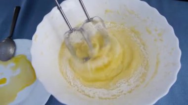 Manzarada para kazanan bir kız var. Mangırı elektrikli mikserle karıştırıyorum. Evde yemek pişirmek..