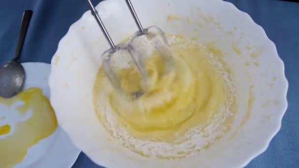 Ovanifrån på en tjej som tjänar pengar. Blandning av deg med elektrisk mixer. Matlagning hemma. — Stockvideo