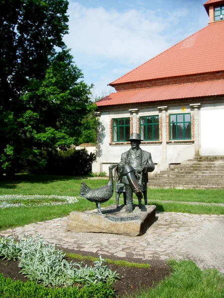 Een monument voor een gans en een man in het park tegenover het herenhuis — Stockfoto