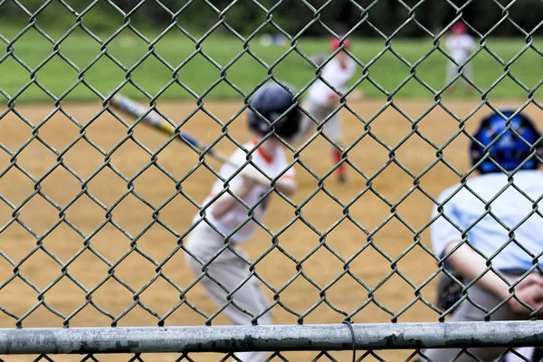 Youth baseball spel sett genom backspärr — Stockfoto