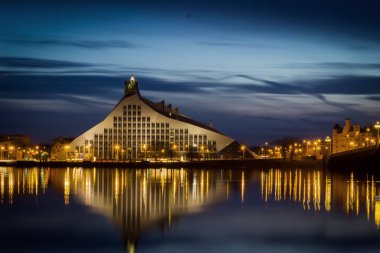 Letonya Milli Kütüphanesi ve Riga'da Daugava Nehri üzerinde taş köprü.