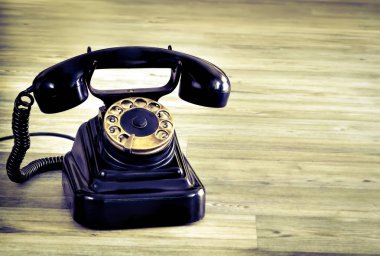 Ahşap masa arka plan üzerinde Vintage siyah telefon