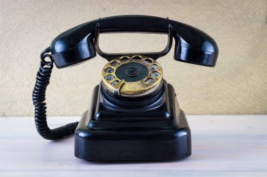 Ahşap masa arka plan üzerinde Vintage siyah telefon