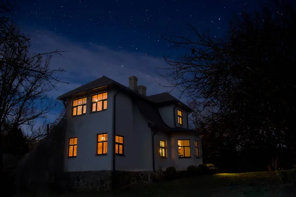Romantik ev penceresinde bir ışıkla. Yaz aylarında gece manzarası