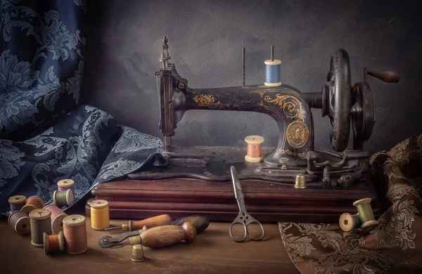 Натюрморт зі швейною машинкою, ножицями, нитками — стокове фото