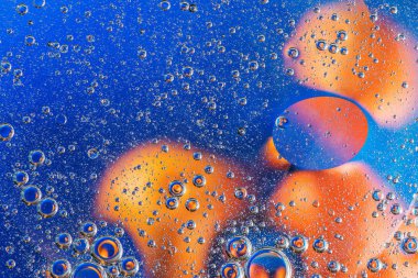 arka plan ile mavi ve turuncu renkli petrol kabarcıklar su yüzeyinde soyut