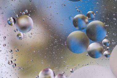 arka plan ile mavi ve sarı renkli petrol kabarcıklar su yüzeyinde soyut