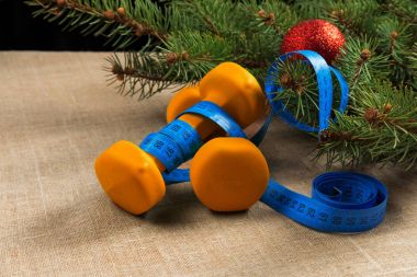 Kırmızı yeni yıl top ve spor için ölçüm bandı ile iki portakal dumbbells fitness Noel ağacı
