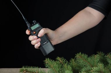 el taşınabilir walkie talkie karanlık bir arka plan üzerinde Noel çam dalları çevresinde