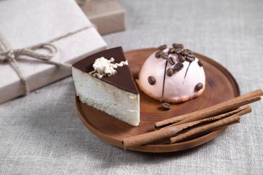 çikolata ve pembe krema ve tarçın sopa ve kahve çekirdekleri kutusunun yanındaki ahşap bir plaka üzerinde bir hediye ile yalan ile çok kolay