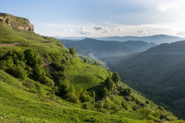 Yeşil dağlar ve tepeler bir yaz akşamı mavi gökyüzü