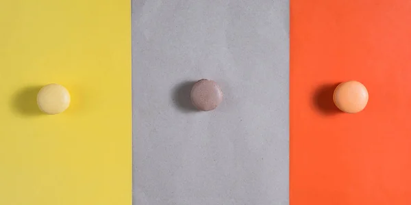 Drie Gekleurde Cake Macarons Zijn Gekleurd Papier Abstractie — Stockfoto