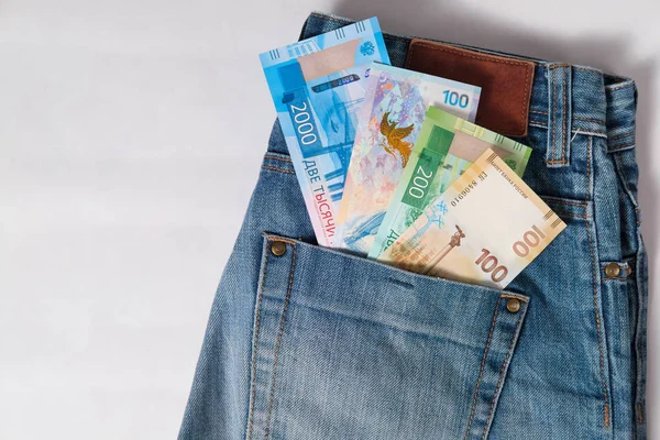 Olimpiyat Oyunları, yeni Rus para banknot ve beyaz arka plan üzerinde kot pantolon cebinde bir dolarlık banknot ile jubilee