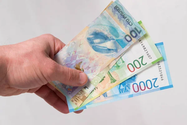 Olimpiyat Oyunları, yeni Rus para banknot ve beyaz arka plan üzerinde adamın elinde bir dolarlık banknot ile jubilee