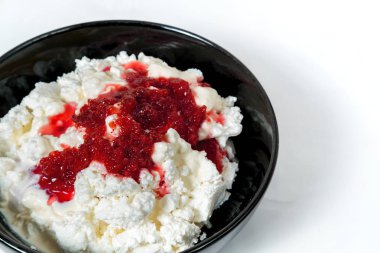 taze ev yapımı yazlık ekşi krema ile peynir ve beyaz arka plan üzerinde Frambuaz reçeli üstüne drizzled