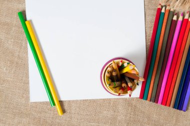 dokulu yüzeyi ve bir sürü eski renkli kalemler üzerinde yalan beyaz kağıdın