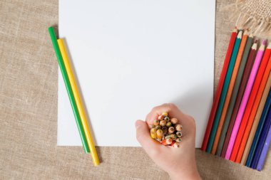 dokulu yüzeyi ve bir sürü eski kağıt yalan beyaz bir levha kalemler el çocuğun renkli.