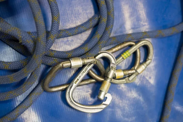 blue rope for climbing in a gym lying on a soft Mat with the old climbing carabiners