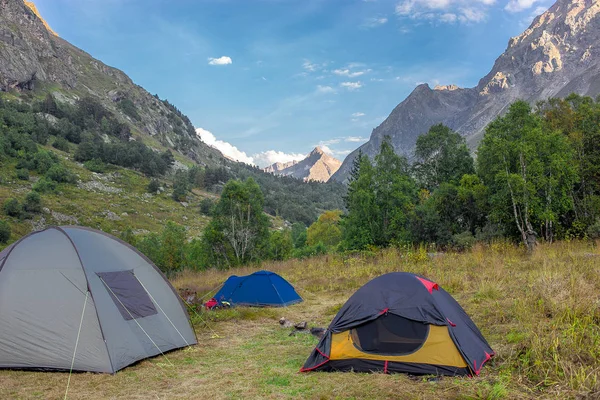 夏の山の峰に囲まれた緑の芝生の上の朝の草原は 観光テント — ストック写真