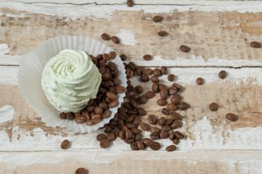 Nane ve elma ek ürünleri ve bir kaba ahşap yüzey üzerinde kahve çekirdekleri ile ev yapımı krema pasta