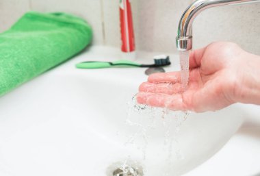 Erkekler el temiz su musluk lavabo üzerinde dökülür