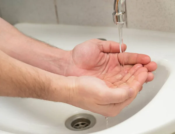 Erkekler el temiz su musluk lavabo üzerinde dökülür