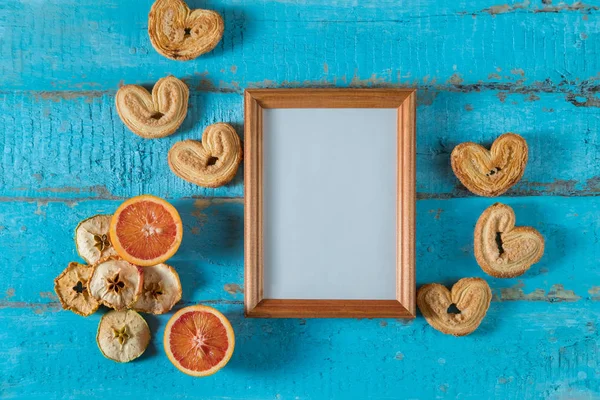 木相框在蓝色木质表面纹理以空白地方为文本或图片以干燥苹果的切片 红色橙色 — 图库照片