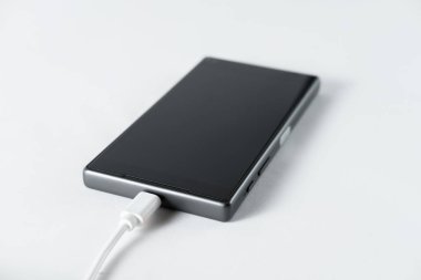 siyah cep telefonu dahil hafif bir arka plan üzerinde şarj tel