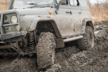 Arabanın tekerlekleri çamura kirli ve suda off-road sürüş stand için sıvı çamur ile donatılmış