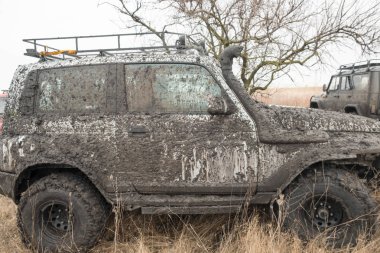 Arabanın tekerlekleri çamura kirli ve suda off-road sürüş stand için sıvı çamur ile donatılmış