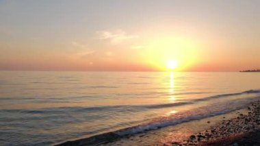 küçük dalgalar ve sıcak yaz aylarında çakıl plajı ile deniz akşam gün batımında güneş