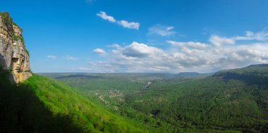 dağlar ve tepeler Adıge bulutlarda beyaz ile mavi gökyüzü parlak bahar gününde yoğun yeşil orman ile büyümüş bir panorama