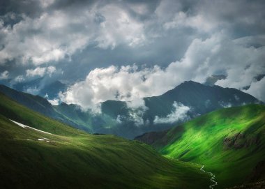 dağ Vadisi ve dağ zirveleri düşük yoğun bulutlar manzara resimde arka tarafından kapalı yamaçlarında kar kalıntıları ile