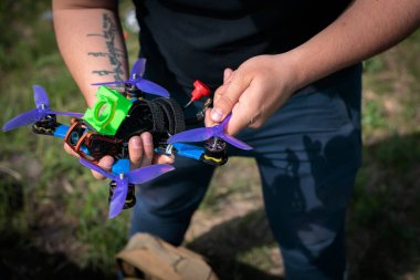 Yarış kuadrokopteri insansız hava aracı açık havada insanların elinde.