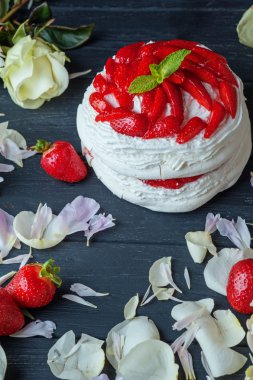 Tatlı kek çilek ve çiçek yaprakları bir ahşap tahta üzerinde