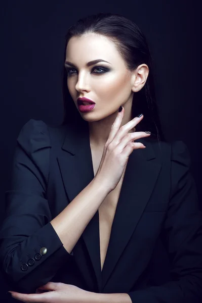 Portrait of sexy strict woman with makeup and fashionable hairstyle poses in studio on black background — Φωτογραφία Αρχείου