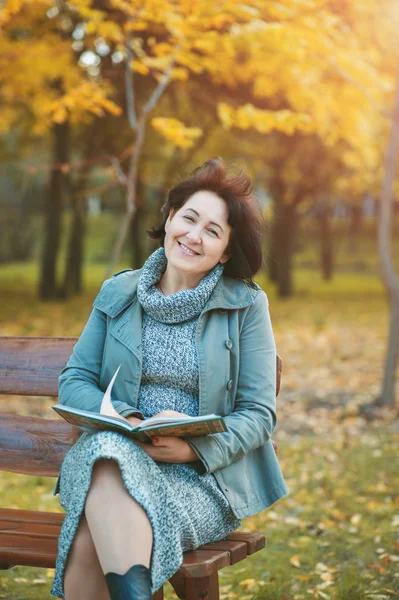 Bir kitap ve realxing zevk parkta oturan üst düzey kadın