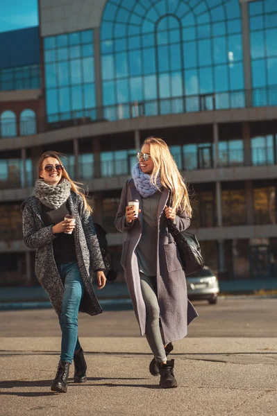 Οι φίλοι με τα πόδια μαζί. Δύο όμορφες γυναίκες περπατώντας μόνος στο δρόμο κρατώντας καφέ και χαμογελαστός — Φωτογραφία Αρχείου