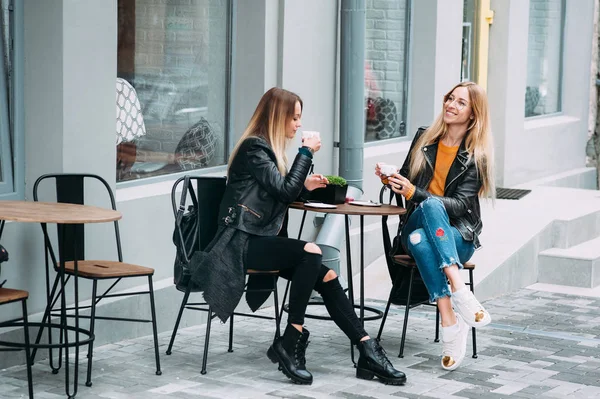 Duas belas jovens mulheres bebendo café e fofocas em bom restaurante ao ar livre. O clima é ótimo e ensolarado para descansar relaxante passar tempo com os melhores amigos — Fotografia de Stock