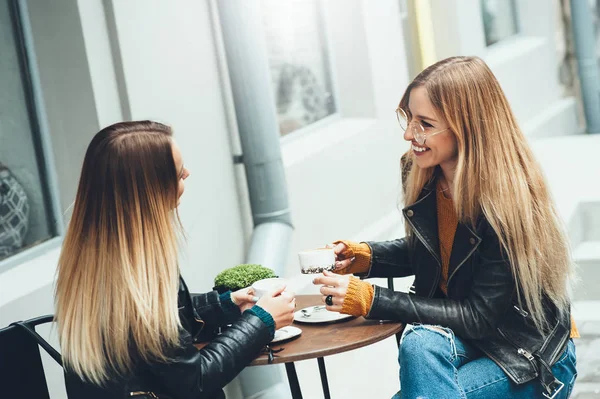 Groep van mooie jonge meisjes met een kopje koffie samen. Twee vrouwen op café praten, lachen, roddelen en genieten van hun tijd. — Stockfoto