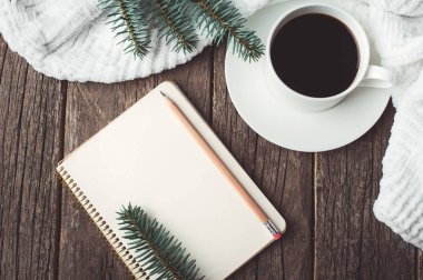 Kış ve sonbahar kompozisyon. Üstten Görünüm vintage defter ile çam ağacı ve kalem, fincan kahve ve örme beyaz ekose ya da eşarp ile dekore edilmiştir. Planları ve dilek Noel tatili üzerinde yazmak
