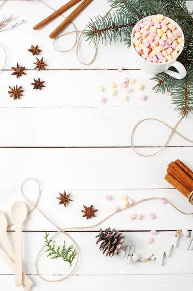 Beyaz masa üzerinde kopya alanı ile kart çerçeve kompozisyon kakao, hatmi, tarçın, anason yıldız, kahve tohumu, çam ağacı, kaşık malzemeler şeyler. Sonbahar mutfak kış kavramları düz Lay