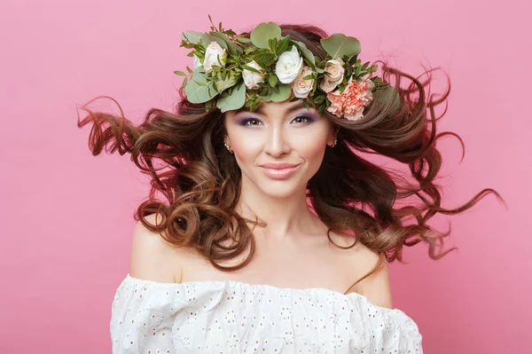 Güzel genç cinsel şehvetli kadın mükemmel cilt ile portre yapmak saç ve çiçekler kafasına pembe bir arka plan üzerinde akış. Çelenk çiçek bahar yaz moda yaşam tarzı insanların kavramları. — Stok fotoğraf