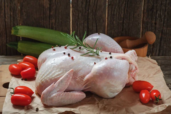 Biberiye domates tuz biber ve kabak ahşap gemide aşçı için hazır çiğ tavuk eti. Rustik arka plan. Gıda mutfak mutfağı sağlık kavramı. Diyet yemek