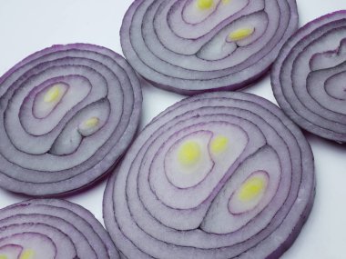 Dilimlenmiş soğan çemberleri beyaz tarafta yan yana. Düz yatma.